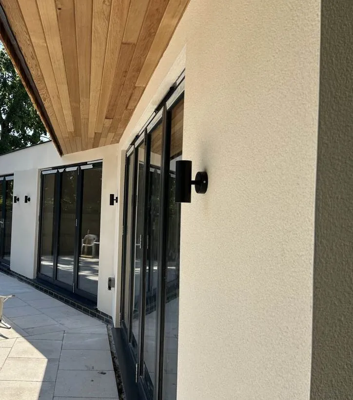 Rear elevation of a new build home with black external wall lights beside bifold doors, Marcham near Abingdon