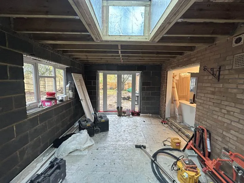Extension shell with exposed joists and a roof lantern opening before any electrical work, Brackley