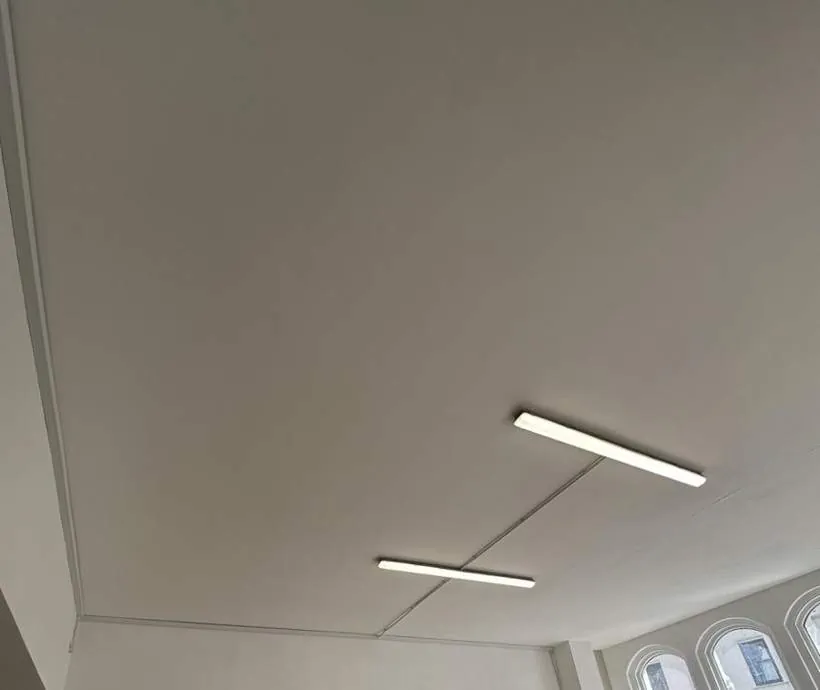 Empty high-ceilinged commercial unit with new LED batten lighting and surface containment, arched shop windows beyond, Banbury
