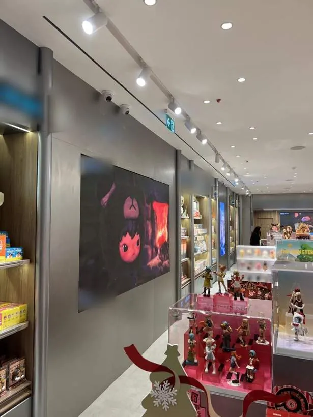Completed retail store with a large LED screen, black track spotlights and ceiling downlights, Oxford