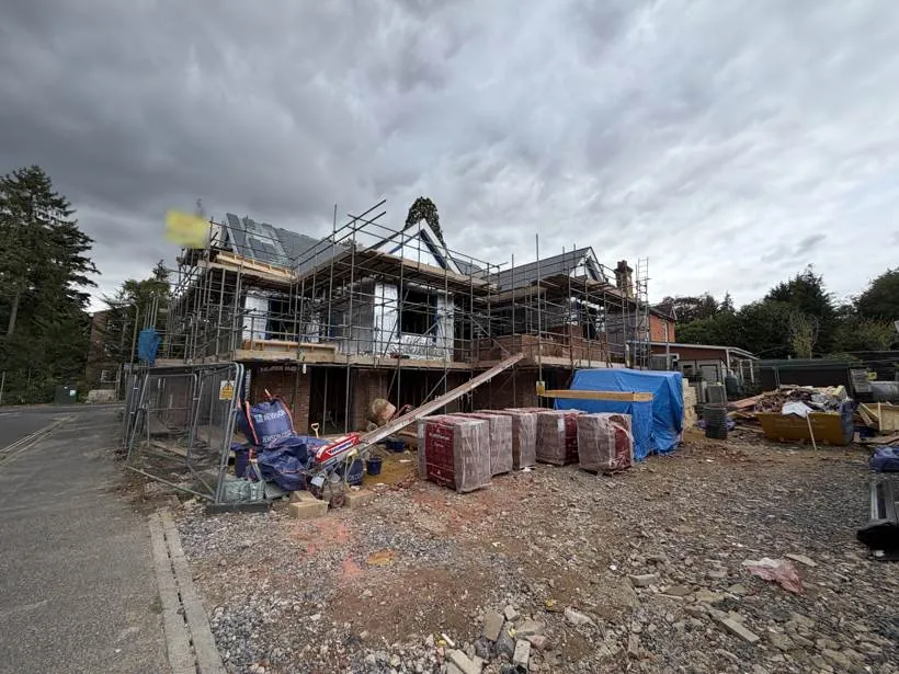 Two new build houses under construction with scaffolding, at first fix stage, Fleet, Hampshire