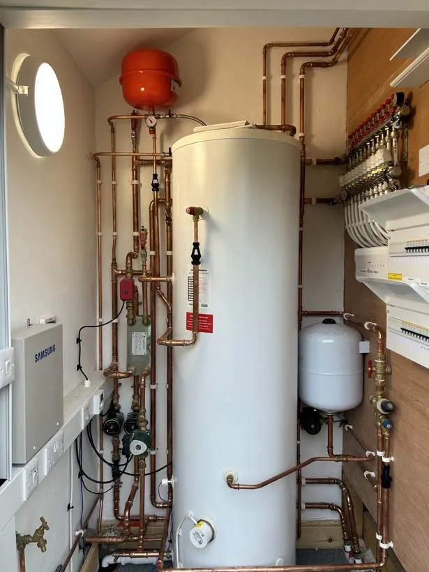 Neatly wired plant room with consumer units, hot water cylinder and heating controls in a self-build home, village near Bicester