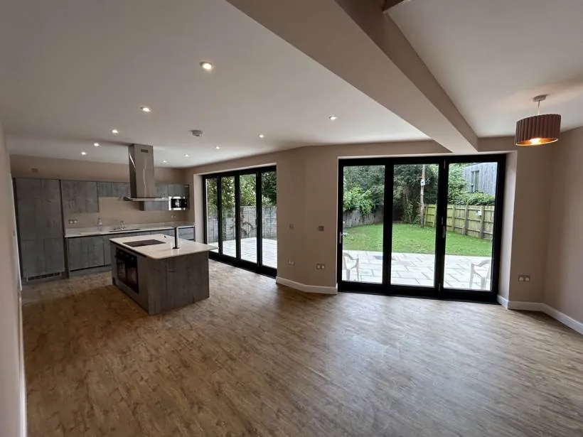 Open-plan kitchen and living area lit by downlights and a pendant, new build home, Marcham near Abingdon