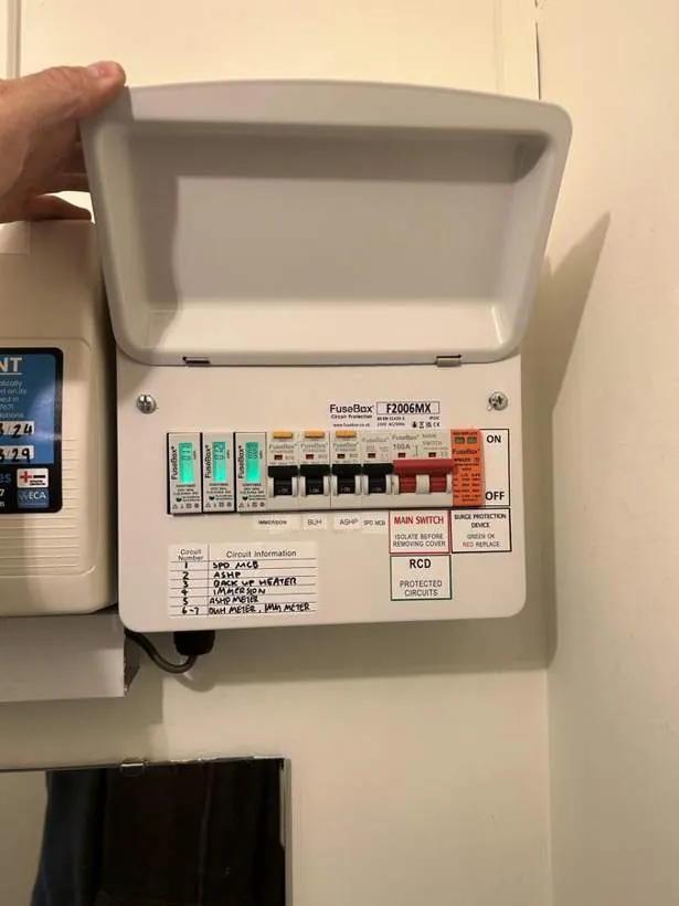 Dedicated consumer unit with labelled circuits for a heat pump and hot water cylinder, alongside DIN rail check meters, Buckinghamshire