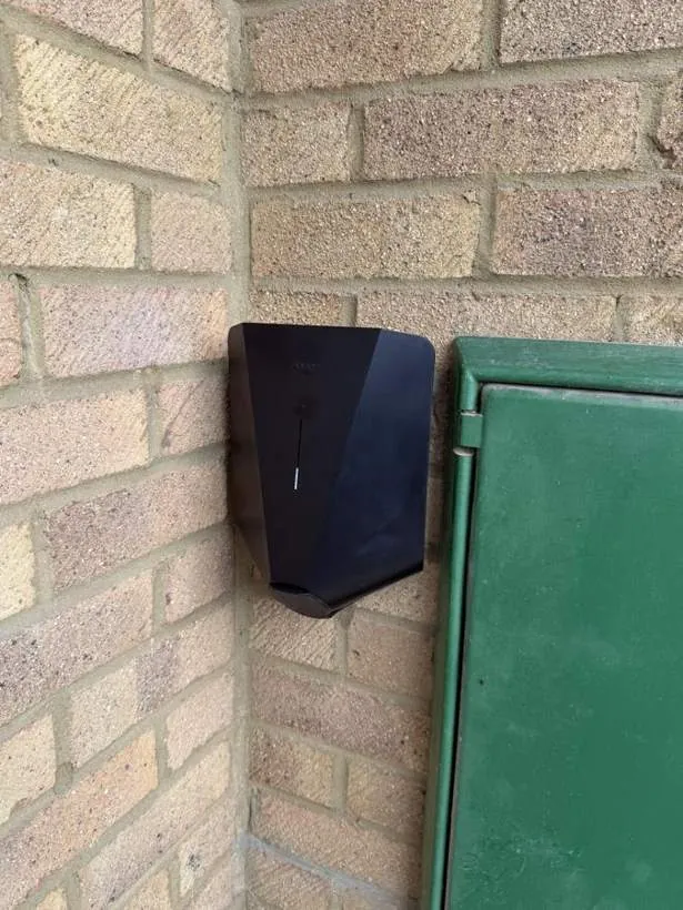 Easee EV charger fitted into a narrow corner beside a meter cabinet, Bicester