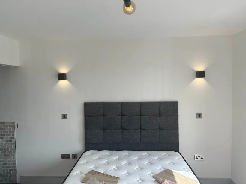 Bedroom with up and down wall lights either side of the bed, new build home at Graven Hill, Bicester