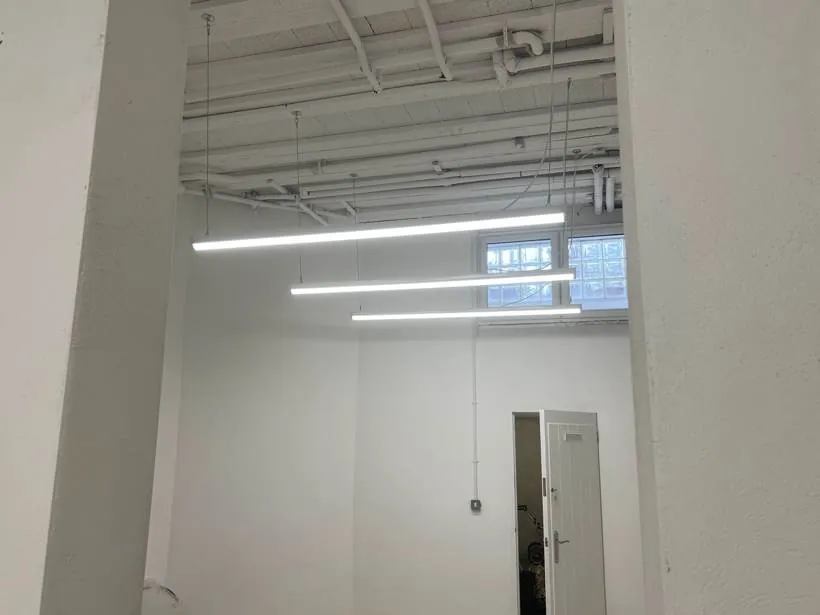 Basement storage area lit by suspended linear LED lights beneath exposed services, Chinnor