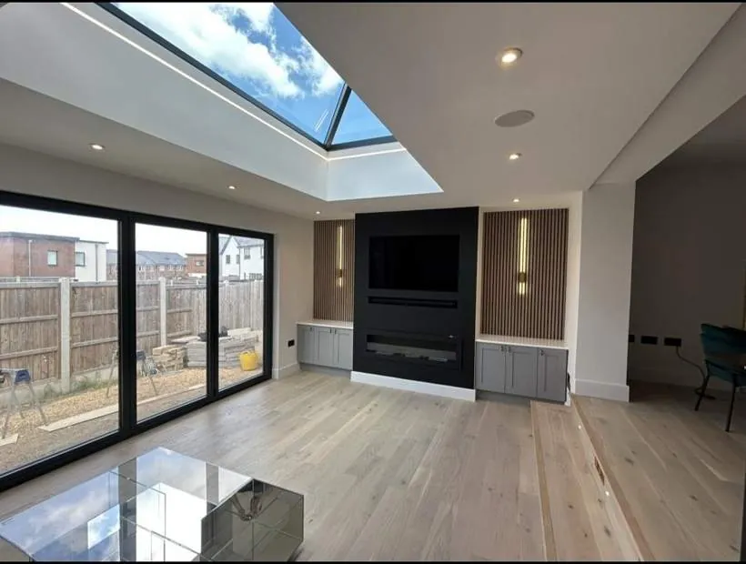 Open-plan extension with a roof lantern outlined in recessed LED strip, downlights, slatted feature wall lights and step lighting, Graven Hill, Bicester
