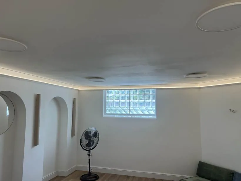 Converted basement living space with warm LED cove lighting and a glass block window, Chinnor
