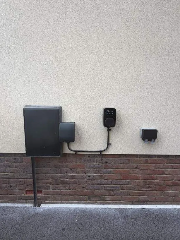 Ohme EV charger, isolator and new weatherproof external socket on a rendered wall, Heyford near Bicester
