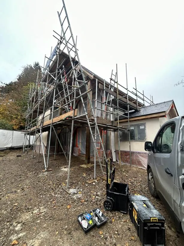 Oak framed self-build house under construction with scaffolding, during the electrical installation, village near Bicester