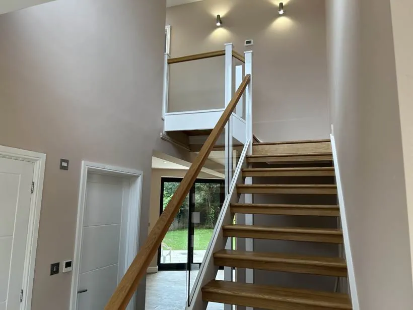 Double-height hallway and oak staircase with wall lights and brushed steel switches, new build home, Marcham near Abingdon