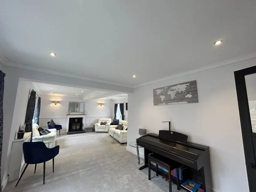 Reshaped living room with recessed downlights and twin wall lights either side of the fireplace, Brackley