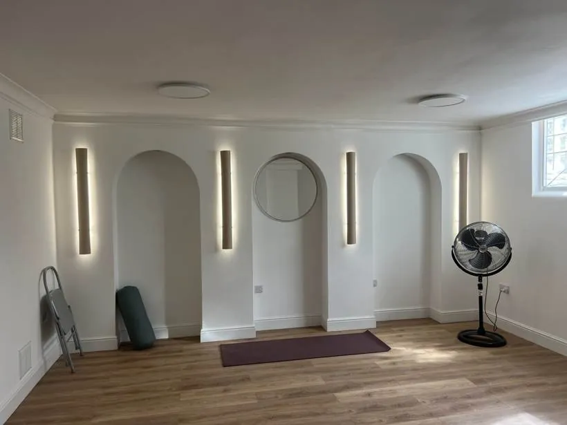 Pilates studio in a converted basement with slim vertical LED wall lights between arched alcoves, Chinnor
