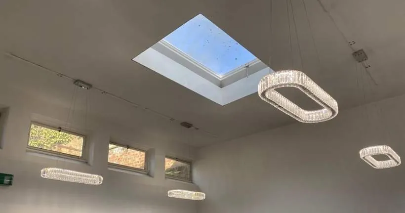 Decorative suspended crystal ring lights in a double-height estate agency office with a roof light, Bicester