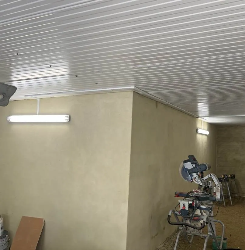 Long basement storage corridor with LED batten lights on a clad ceiling, Chinnor