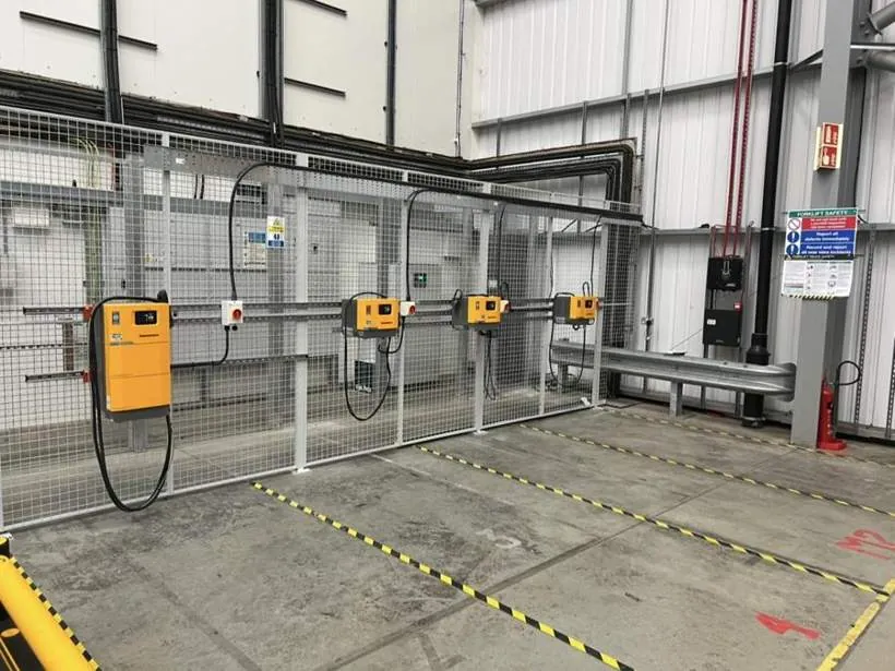 Forklift charging bay with four chargers, isolators and cable tray mounted on mesh partitioning, Bicester