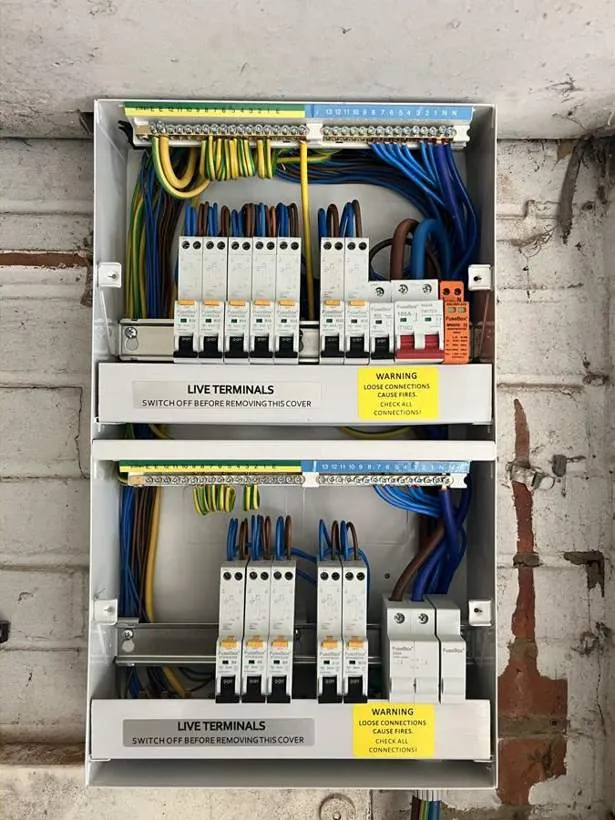 Two neatly dressed consumer units with RCBO and surge protection, installed as part of a full rewire and two-storey extension, Adderbury