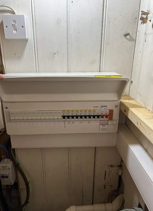 Consumer unit in its new under-stair position with cover fitted and trunking running to it, Summertown, Oxford