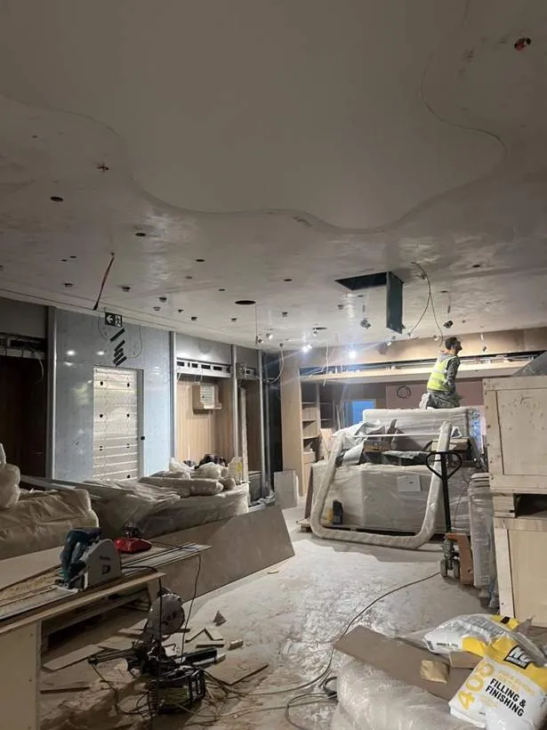 Shop unit mid strip-out with ceiling opened up and first fix electrical work under way