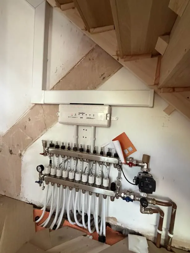 Underfloor heating manifold with pump and wiring centre installed beneath the stairs, Bloxham