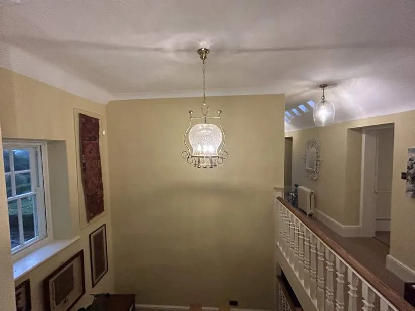 Glass pendant lights hanging over a galleried landing with white balustrade
