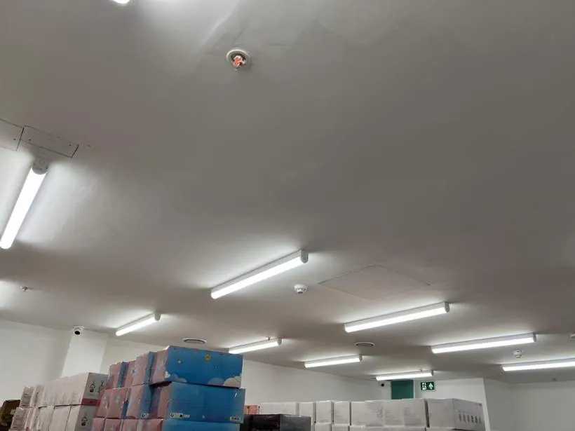 Stockroom lit by LED battens with fire alarm detection on the ceiling, retail store in Oxford