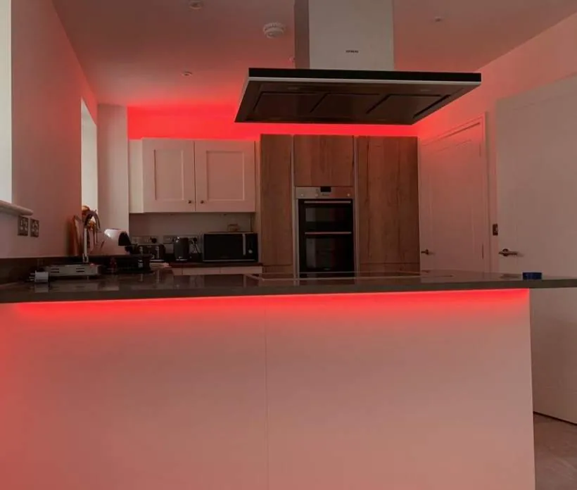 Kitchen with red RGB LED strip lighting glowing beneath wall units and the island worktop, Bicester