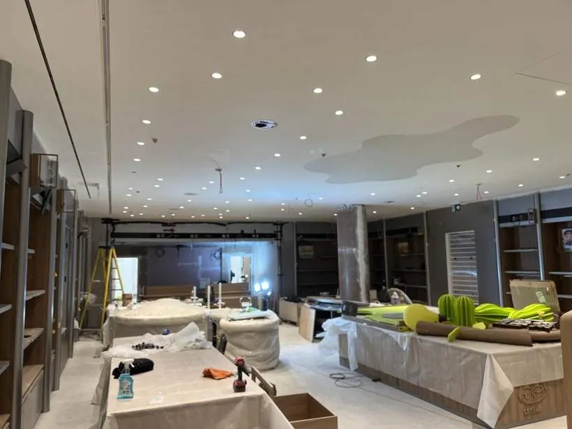 Shop floor during the fit-out with new ceiling downlights and containment installed and joinery being fitted