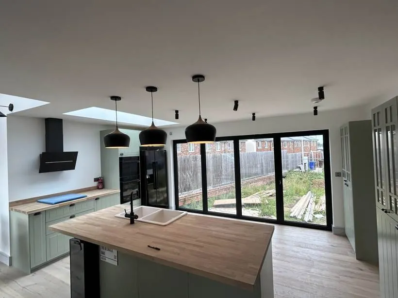 Open-plan kitchen with feature pendants, black spotlights and roof lights, new build home at Graven Hill, Bicester