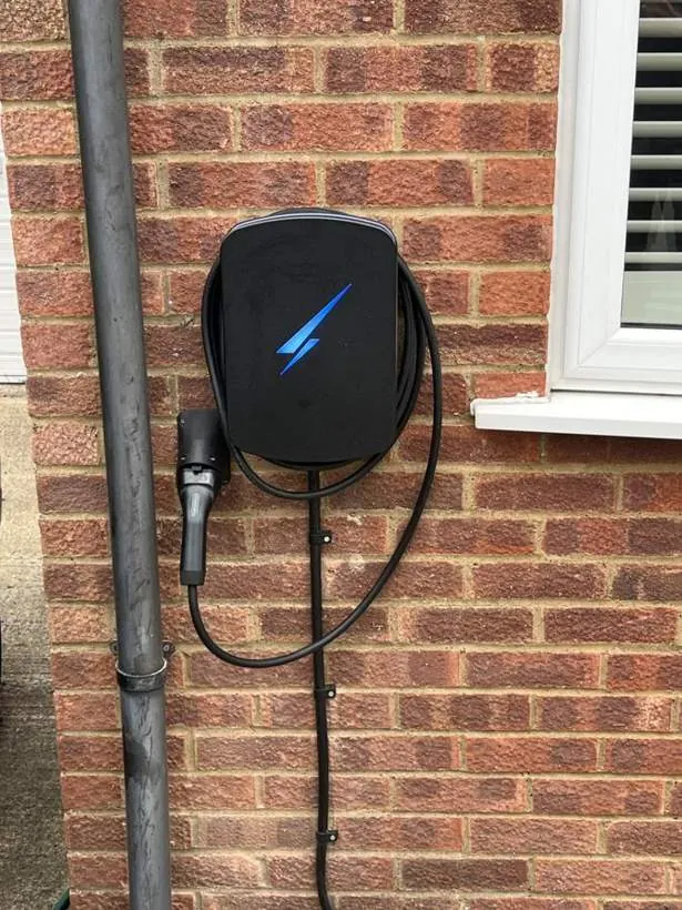 Black Hypervolt EV charger on a brick wall beside a downpipe, Faringdon, Oxfordshire