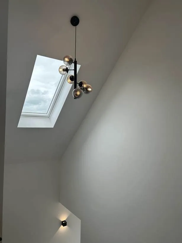 Stairwell with a feature cluster pendant beneath the roof light, new build home at Graven Hill, Bicester